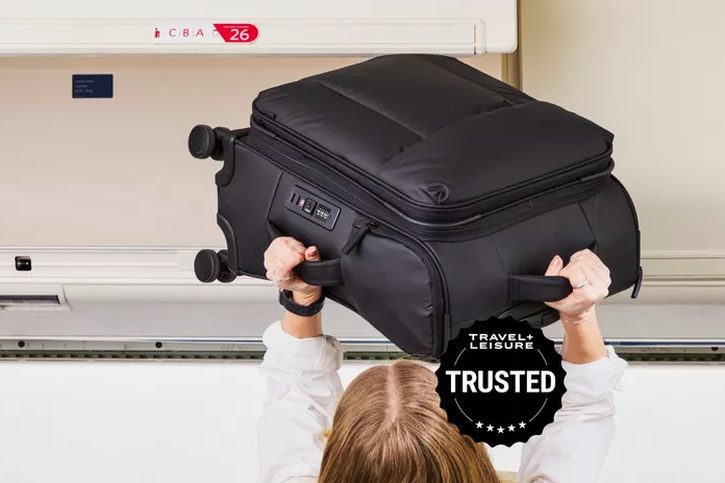 four carry-on suitcases lined up side by side on a hardwood floor